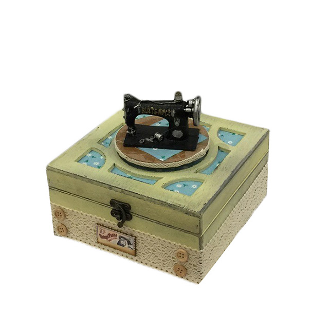 Caja musical de madera con máquina de coser