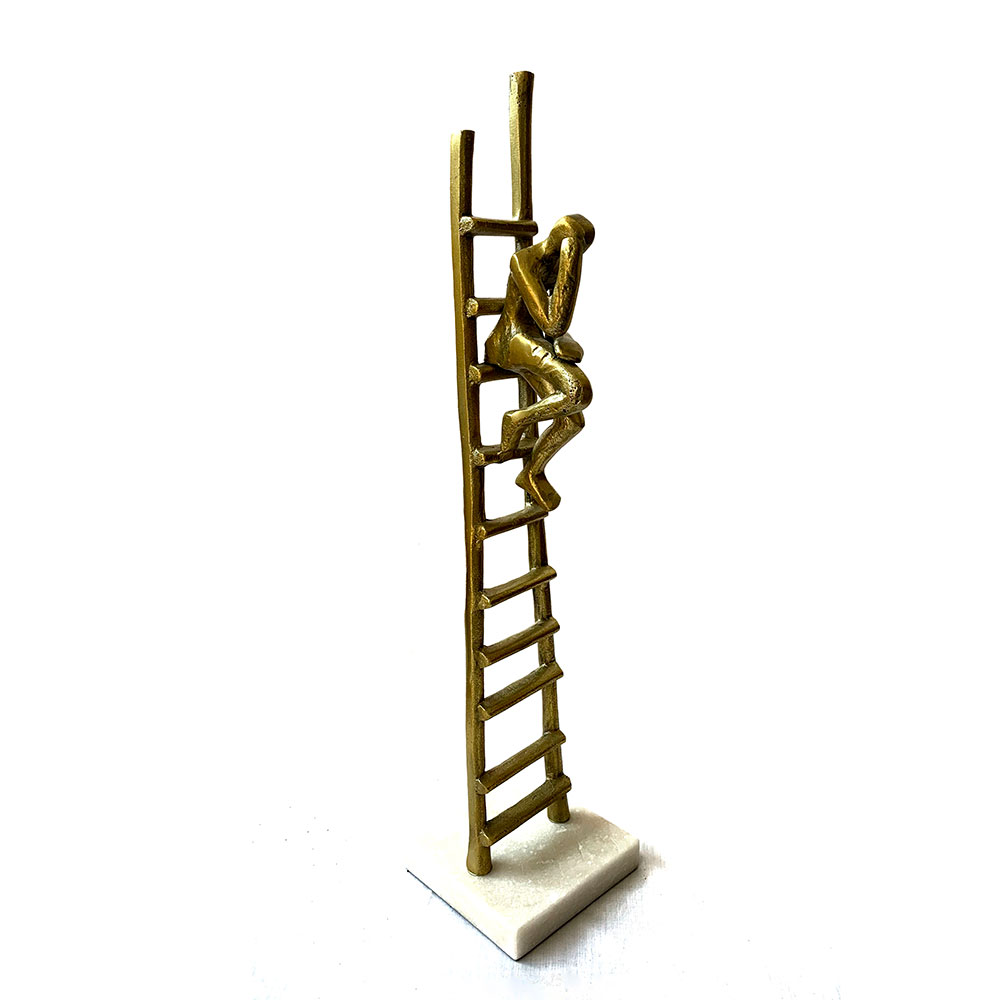 Escultura de persona pensando sobre escalera