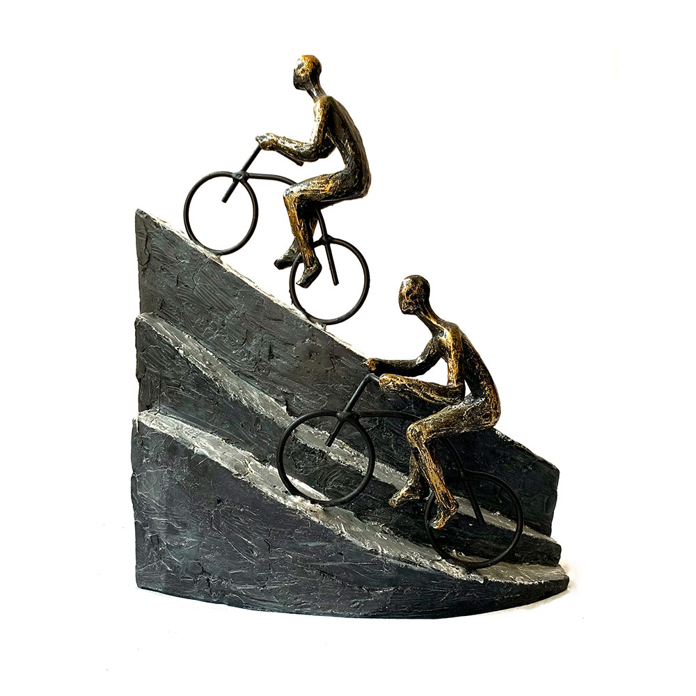 Escultura de personas subiendo montaña en bicicleta