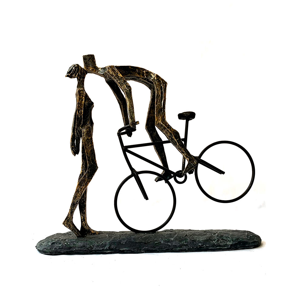 Escultura de pareja besándose sobre bicicleta