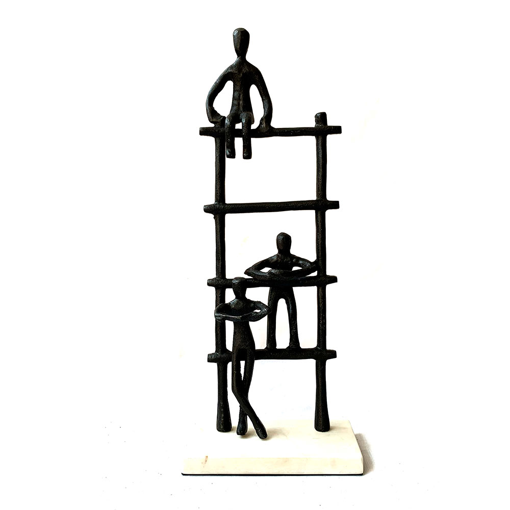 Escultura de personas sobre escalera