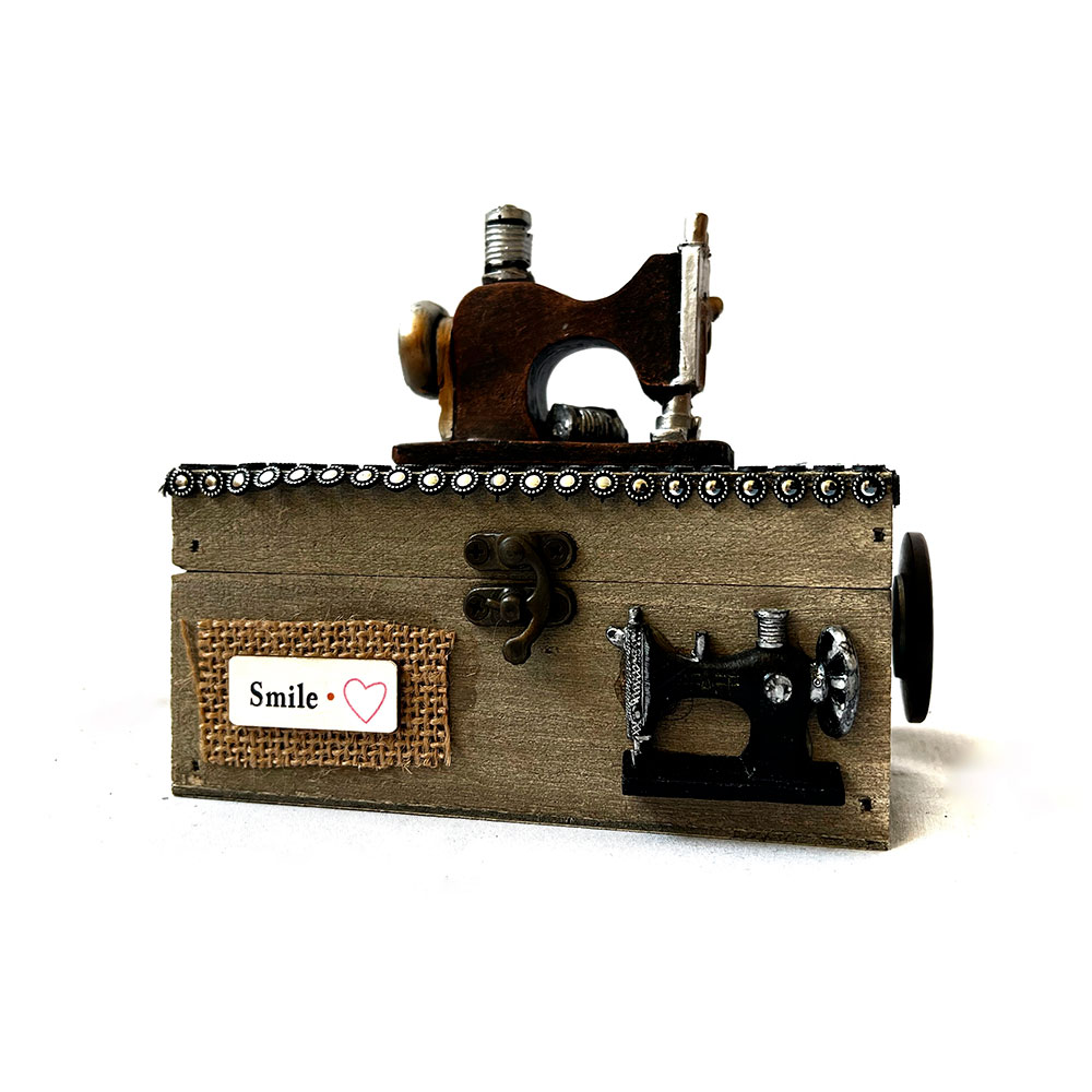 Caja musical de madera con máquina de coser