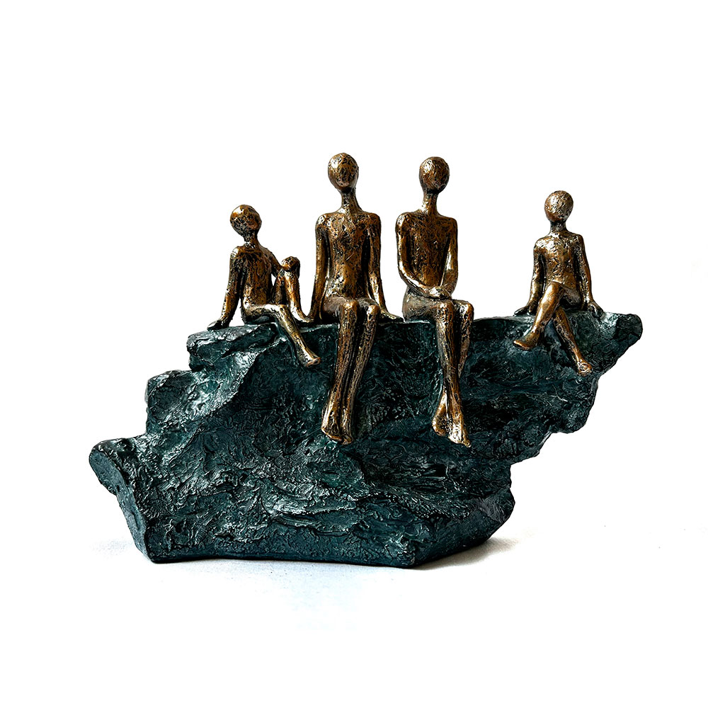 Escultura de familia de cuatro sentada en roca